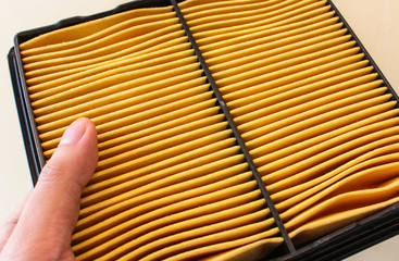 hand holding an new of car air filter isolated on background