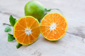 Fresh Orange Slice Cut half orange fruit harvest from the garden with green leaf on wooden background