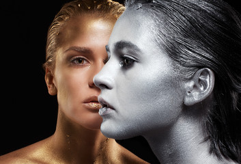 Beauty portrait of young gorgeous women. Golden and silver girls on black background