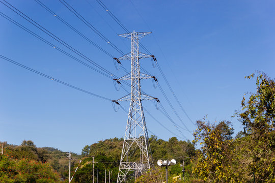 High voltage transmission towers with mountain Background and blue sky