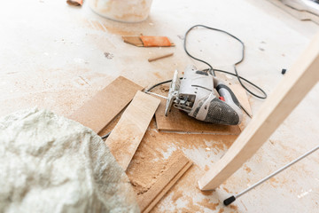 Close-up tools for cuts the laminate Board with an electrofret saw. installing new wooden laminate flooring. concept of repair in house.