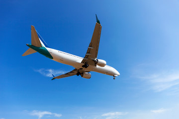 Passenger airplane landing clear blue sky and clouds background