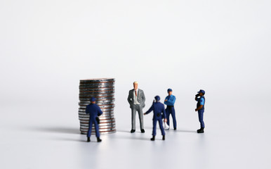 Miniature people with a pile of coins. Concepts for safe asset management.