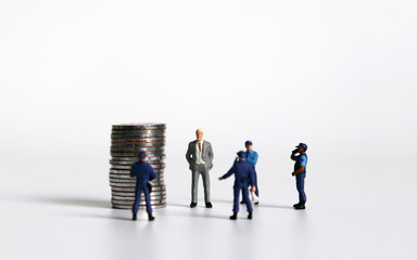 Miniature people with a pile of coins. The concept of social problems about financial fraud.