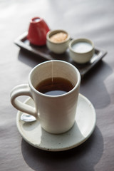 Hot tea served in a mug with milk and sugar