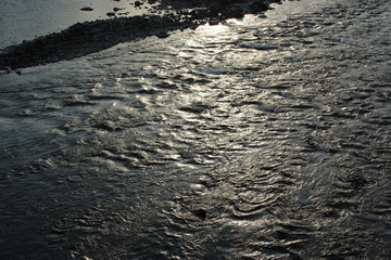 Sunlight creates a shiny ripple reflection on water
