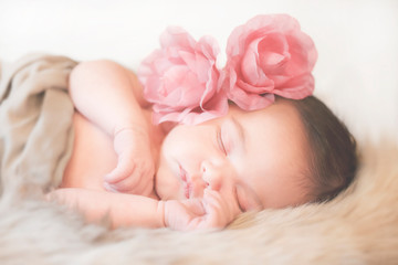 Obraz na płótnie Canvas schlafendes Baby mit Blumen im Haar