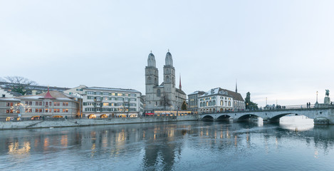 Zurich, ZH / Switzerland - January 4, 2019: many people crossing a bridge over the Limmat on their way to the Grossmuenster cathedral in Zurich