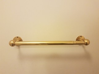 brass or gold colored bar on white wall