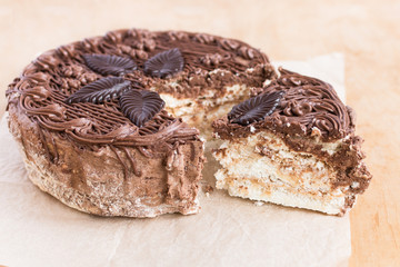 Chocolate cut cake top view on wooden background table. Sweet dessert.