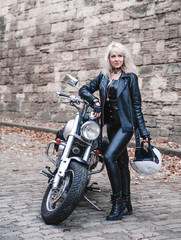 Plakat Beautiful biker woman posing outdoor with motorcycle.