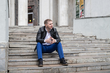 Fototapeta na wymiar Portrait of handsome young man on the steps