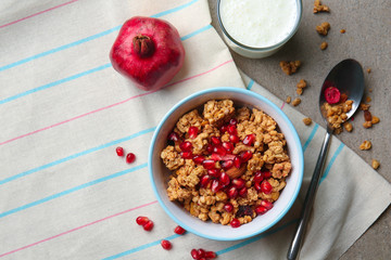 Granola with pomegranate seeds in bowl on table