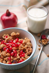 Granola with pomegranate seeds in bowl on table