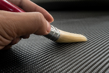 Black carbon fiber with hand holding the brush