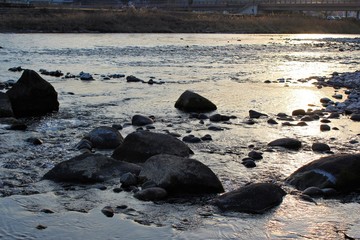 Fototapeta na wymiar Surface of the Kuma River sparkles in the winter sunlight
