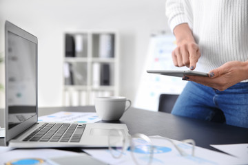 Young woman with modern devices working in office