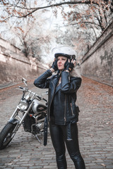 Fototapeta na wymiar A beautiful woman posing woth motorcycle outdoors. 