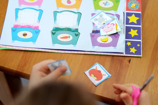 girl with scissors in hand with glue pencil makes applications