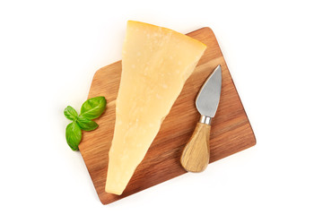 Aged Parmesan cheese with fresh basil leaves and a cheese knife, shot from above on a white background with copy space