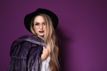 Fashionable young woman on violet background