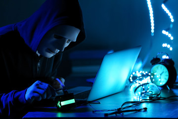 Professional hacker working in dark room