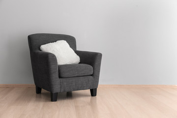 Comfortable armchair near light wall