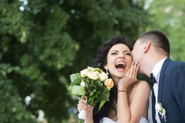 Bride and groom at wedding day outdoor on spring nature. Bridal couple, happy newlywed woman and man embracing in green park. Loving wedding couple outdoor. Bride and groom