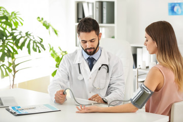 Male doctor working with female patient in clinic