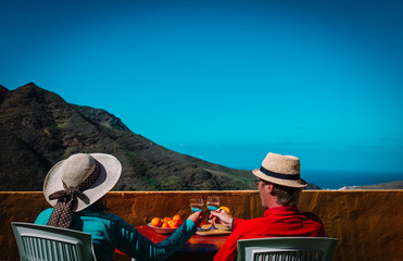 young couple drink wine on balcony terrace with scenic view