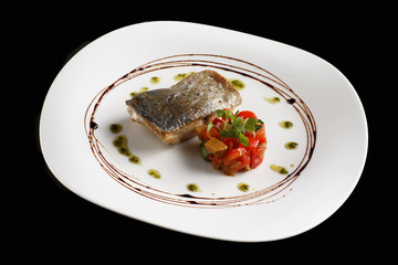 Dish of fish fillet with lettuce and lemon on plate
