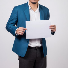 Businessman showing  blank white paper.