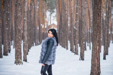 Fototapeta na wymiar Elegant and casual female beauty. Attractive lady in grey fur coat, nice girl in park, lifestyle of woman, pretty arabic face 