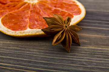 dried grapefruit and anise stars on wooden background