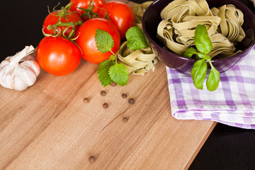Italian pasta on wood background. Vegetables, pasta and basil. Garlic.