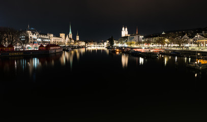 Fototapeta na wymiar Zurich, ZH / Switzerland - January 4, 2019: night time city skyline view of Zurich with the river Limmat
