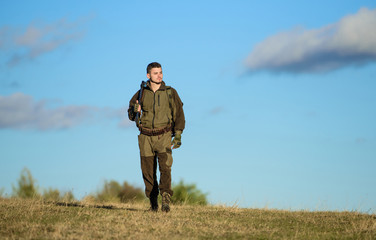 Guy hunting nature environment. Masculine hobby activity. Man hunter carry rifle blue sky...