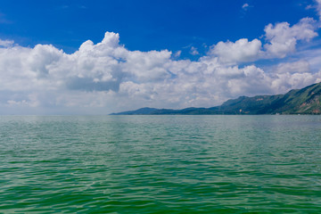 Calm water of Dianchi Lake and Western Hills under blue sky and clouds, in Kunming, China