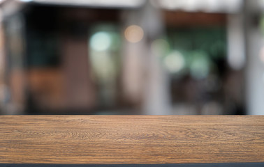 Fototapeta na wymiar Empty dark wooden table in front of abstract blurred bokeh background of restaurant . can be used for display or montage your products.Mock up for space.