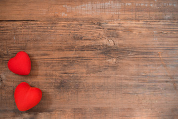Fototapeta premium Pair of red hearts on vintage wooden table top view. Saint Valentines day greeting card.