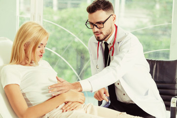 Male doctor is talking and examining female patient in hospital office. Healthcare and medical...