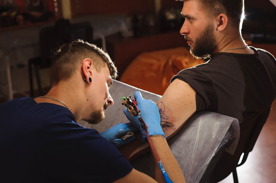 Tattooist makes a tattoo.