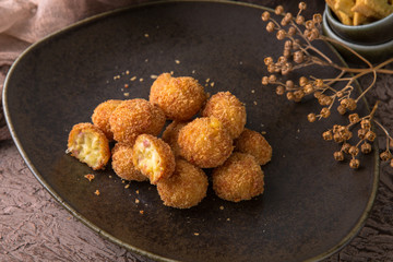 Fried potatoes balls with meat on black background. Snack to beer. Fast food.