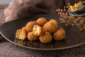Fried potatoes balls with meat on black background. Snack to beer. Fast food.