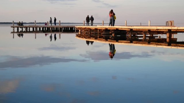 Vlore, Albania - december 28 2018: tourists on the wooden walkway  at sunset on Zvernec Island in lagoon of Narta, Byzantine St. Mary's Monastery
