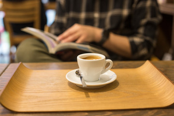male hands holding book with coffee