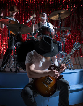 Three men play musical instruments