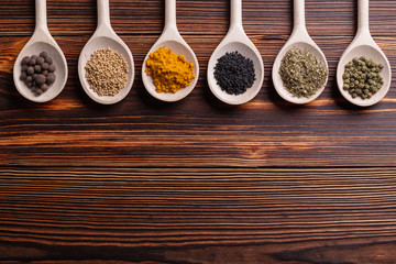 Mixed spices and herbs on wooden spoons with copy space.