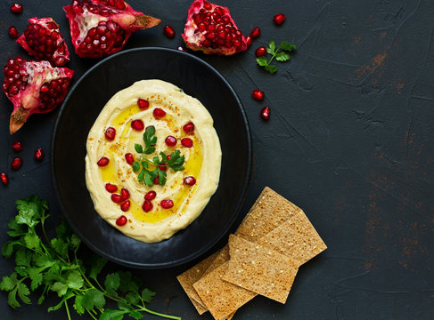 Traditional hummus, with pomegranate and cereal loaves. selective focus.
