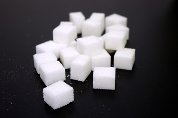 White sugar cubes on black background, Sugar prices globally, unhealthy lifestyle 